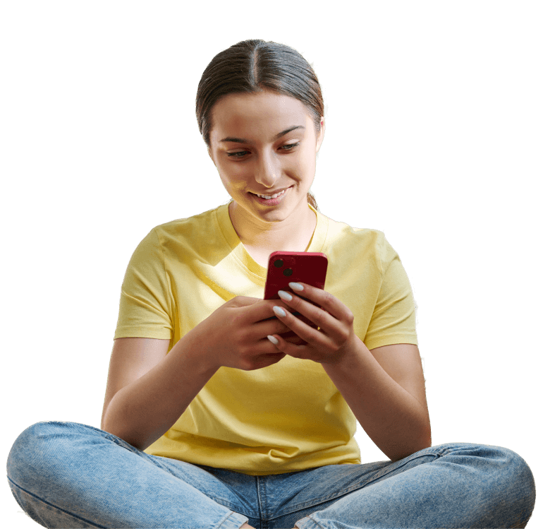 A girl sitting on the floor looking at her phone.